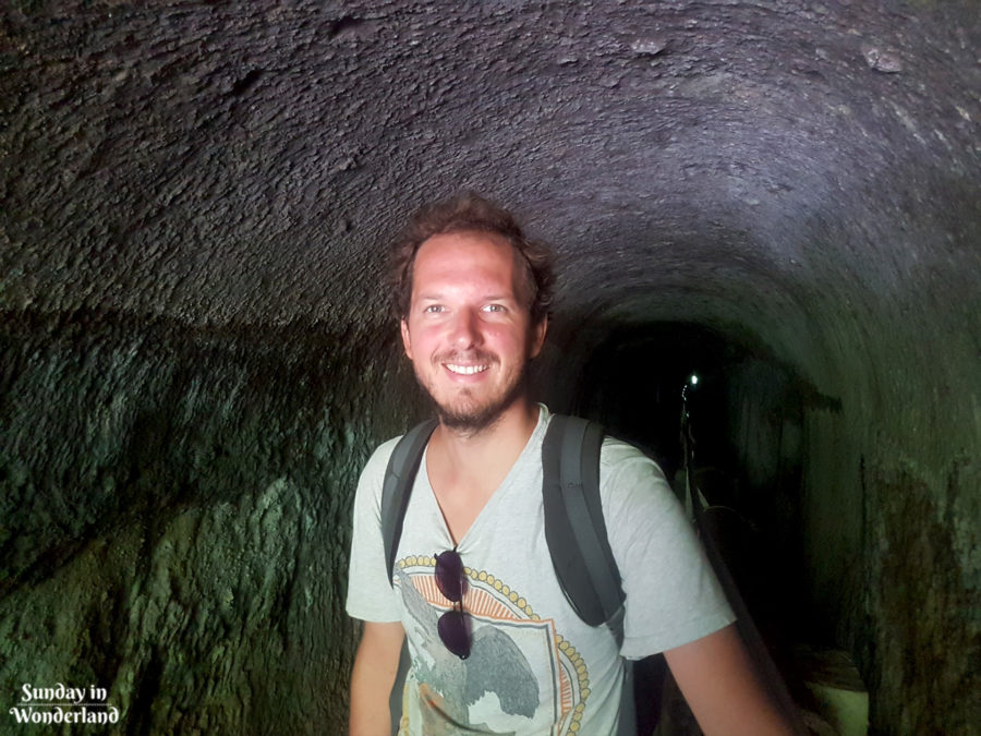 A happy traveller in a tunnel leading Didier Waterfall - Martinique - Sunday in Wonderland Blog
