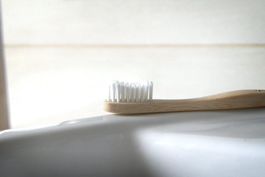 Bamboo toothbrush laying on the sink for natural mouth care