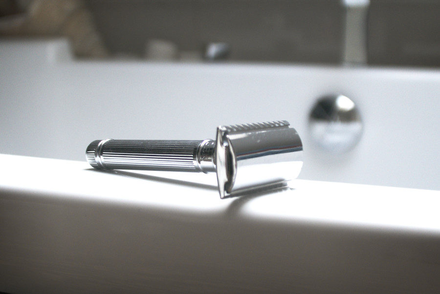 Stainless Steel Razor laying on the bath - improve your zero waste beauty routine