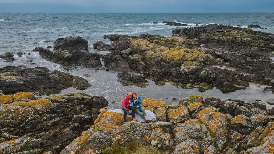 France, two people sitting at rocks on the Bretagne's coast