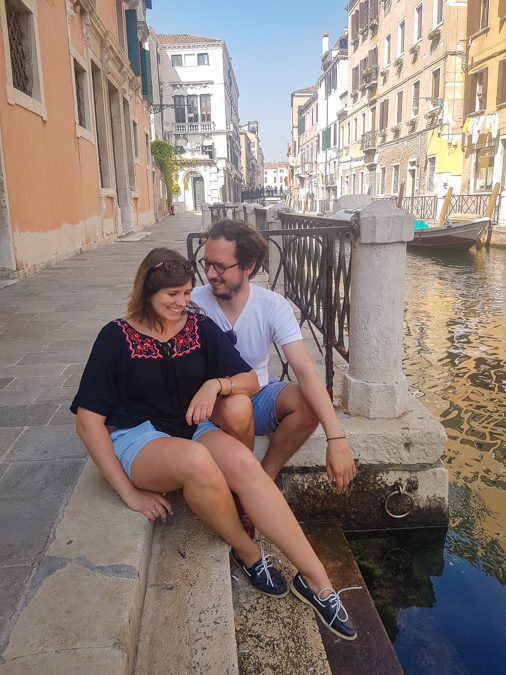 A couple sitting by the canal in Venice